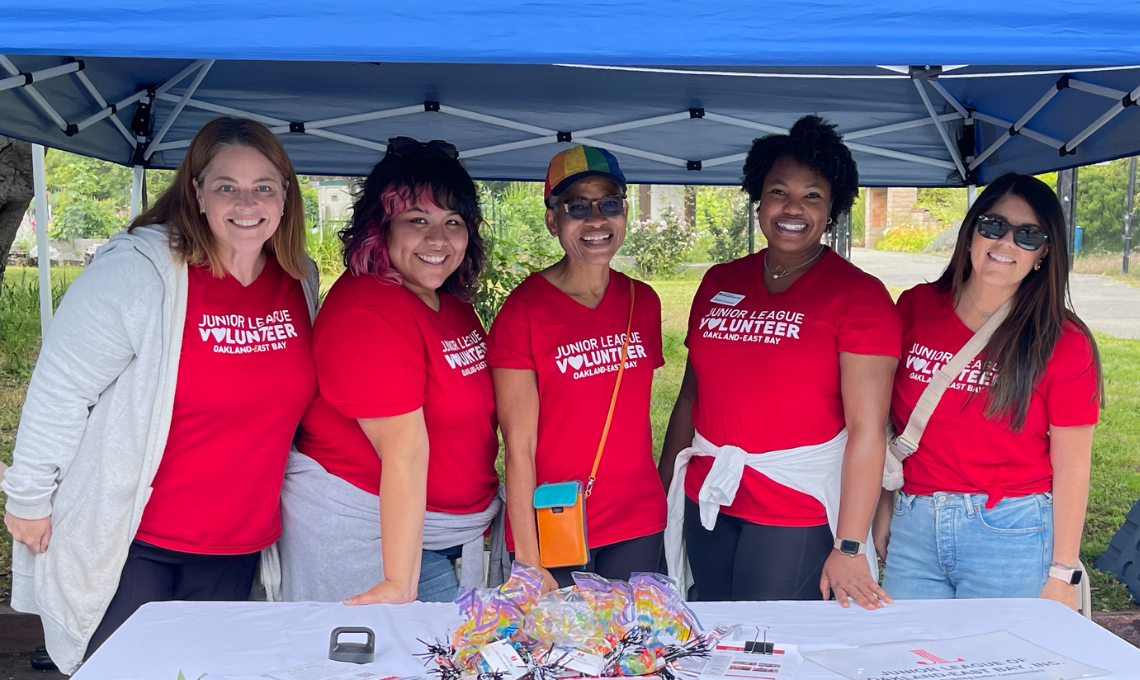 Group of JLOEB members in their branded volunteer shirts staffing a recruitment table at an event in Oakland.