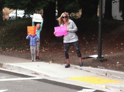 Heather Craig and her daughters showing off their signs to support the walkers.